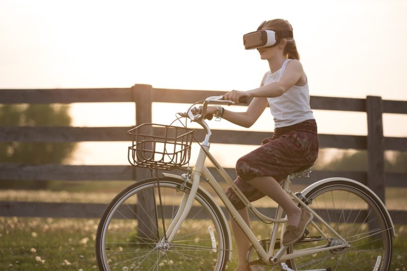VRヘッドセットを付けて自転車に乗るイメージ